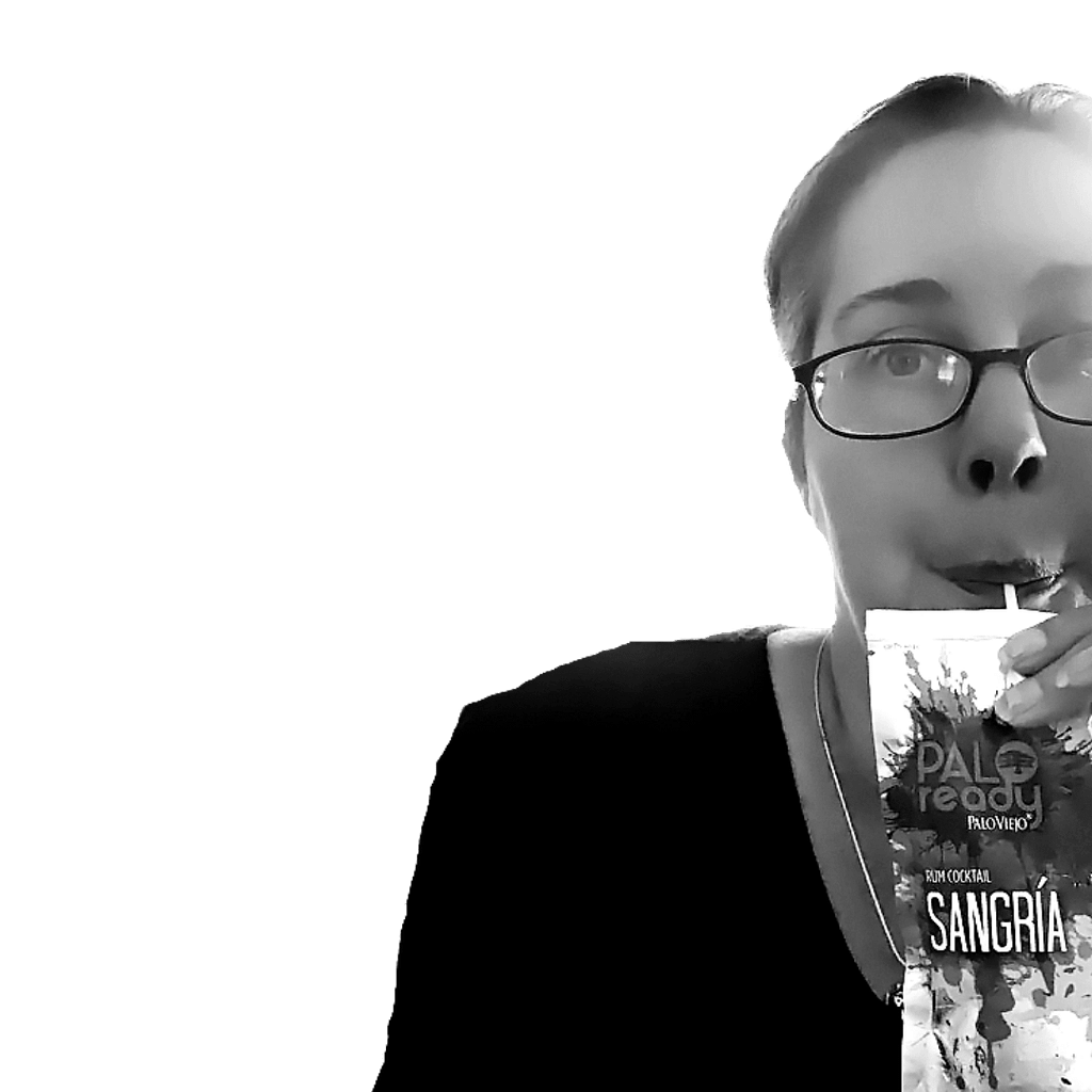 Black and white photo of Michelle Grewe drinking what appears to be a Capri Sun juice pouch but it's Sangria with rum in it. 