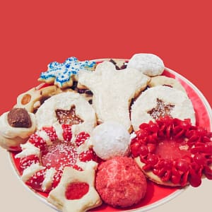 Photograph of Christmas Cookies including a Christmas Angel, Cinnamon Wreath, Hershey Kiss Surprise, Werther Original Stars, Blue and White Snowflake, almond wedding cookies, and Welch's Fruit Chew stars.