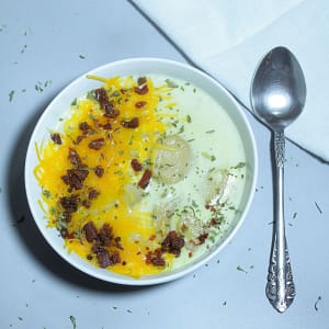 Photograph of Easy Potato Soup covered in melted cheese and bacon bits.